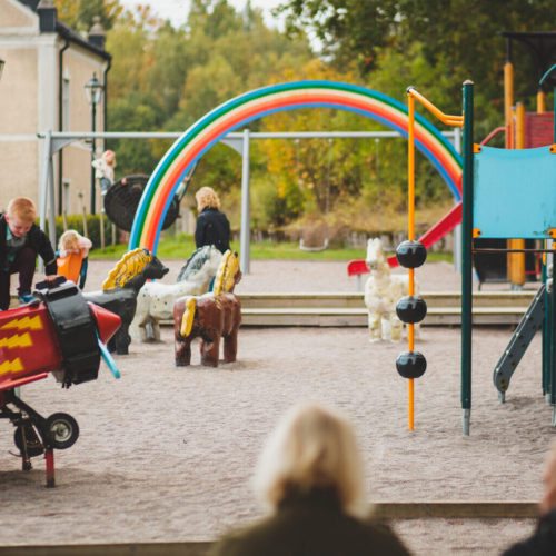 Barn leker på en lekplats där det finns lekställning, flygplan och gungor