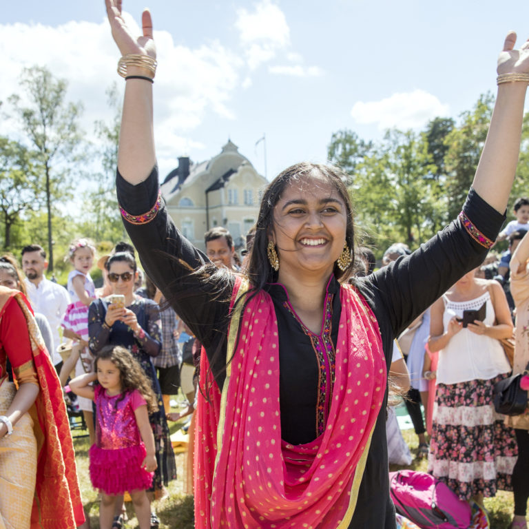 Leende och dansande kvinnor i färgglada indiska kläder